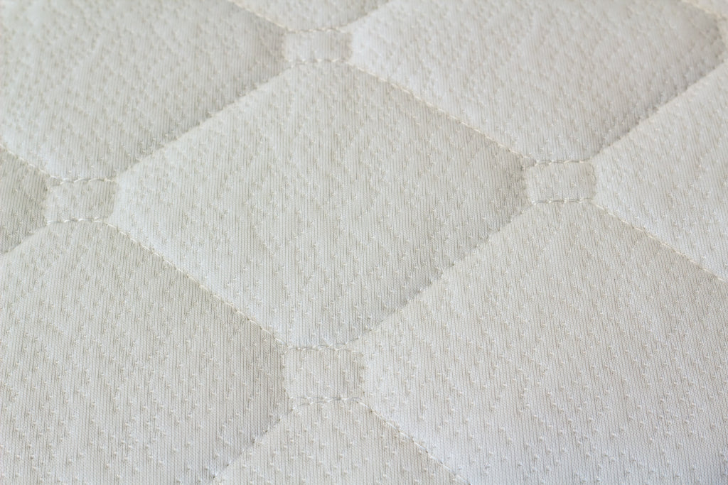 Close-up of a textured white mattress surface