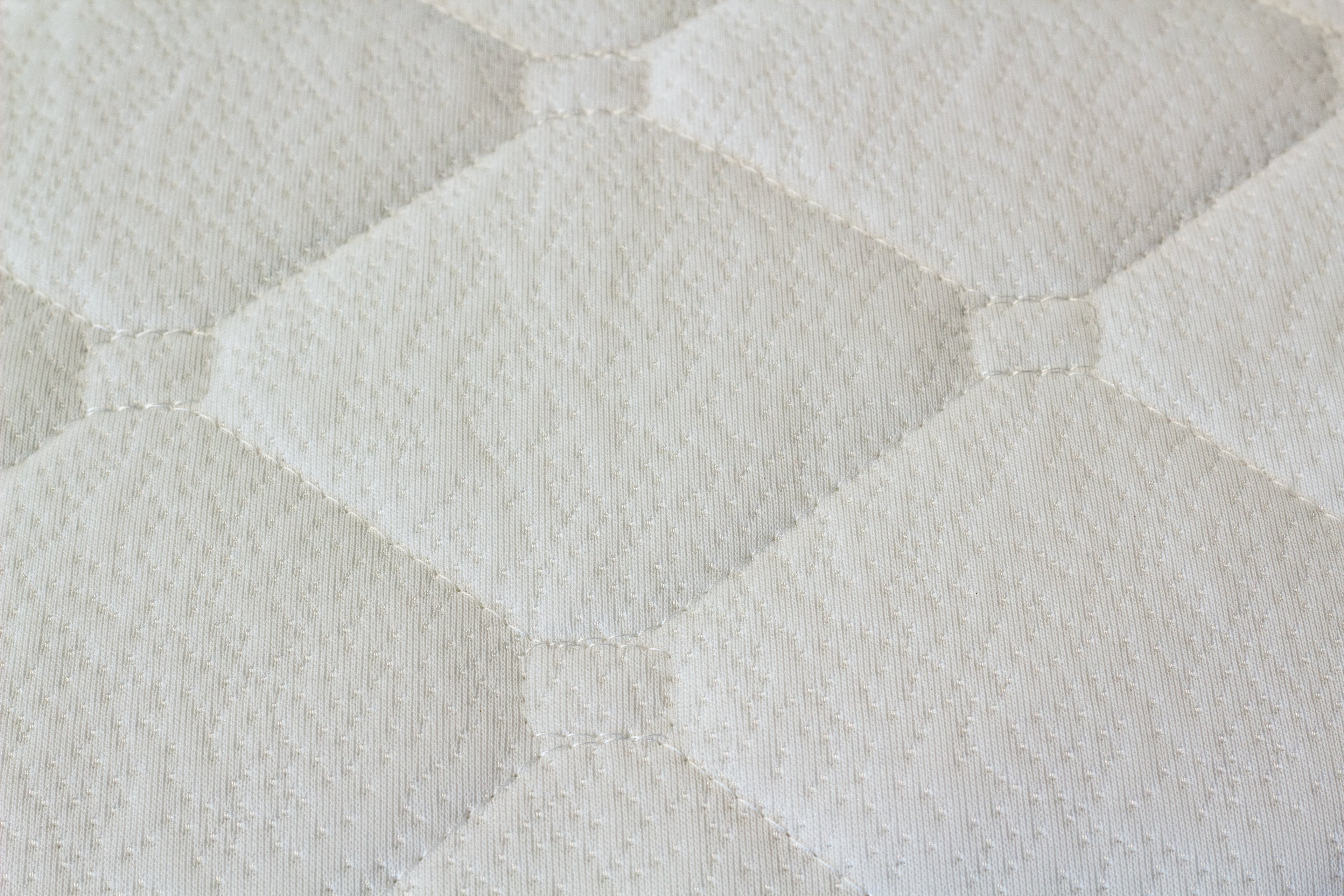 Close-up of a textured white mattress surface