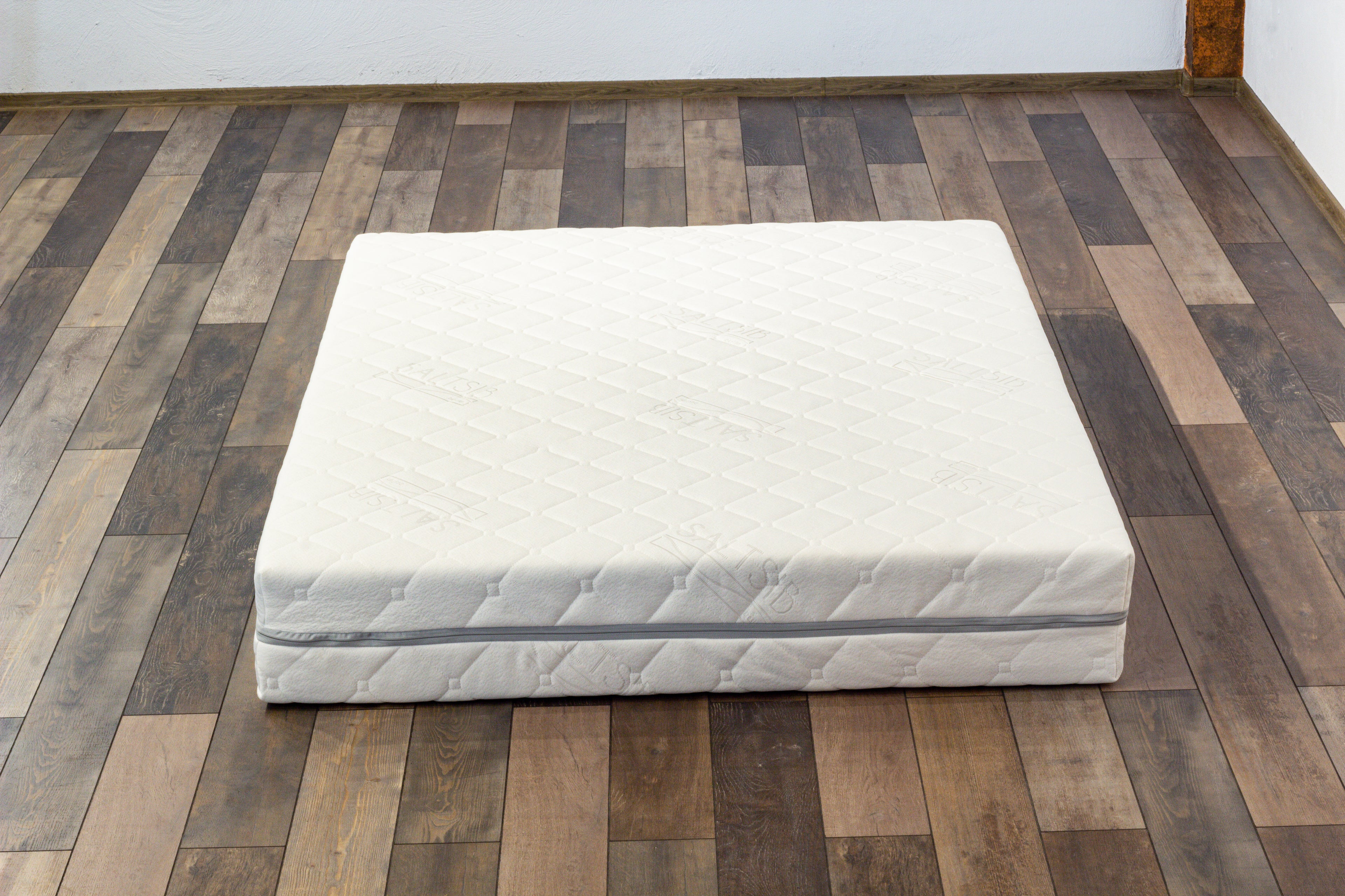 White mattress on a wooden floor