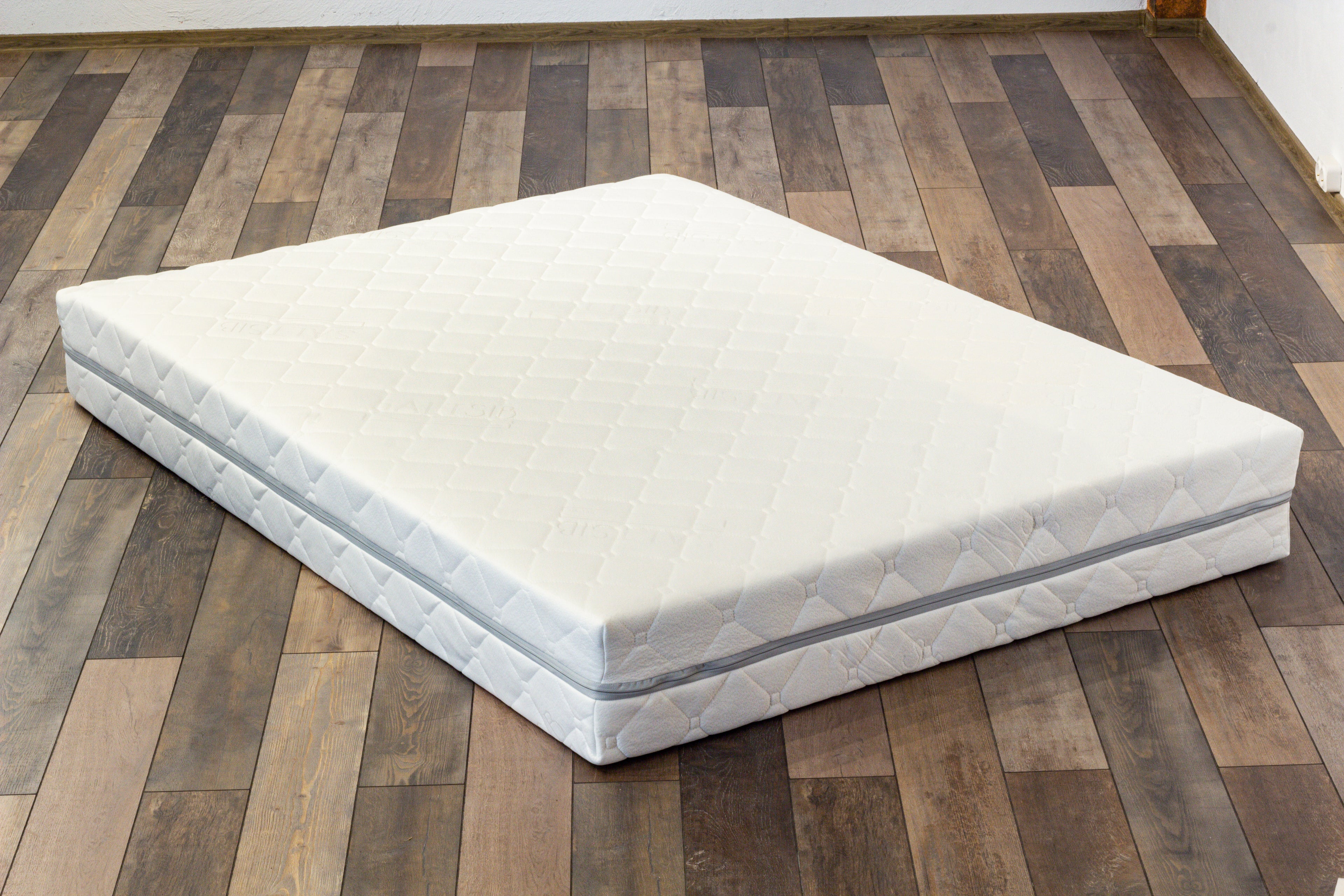 White mattress on a wooden floor
