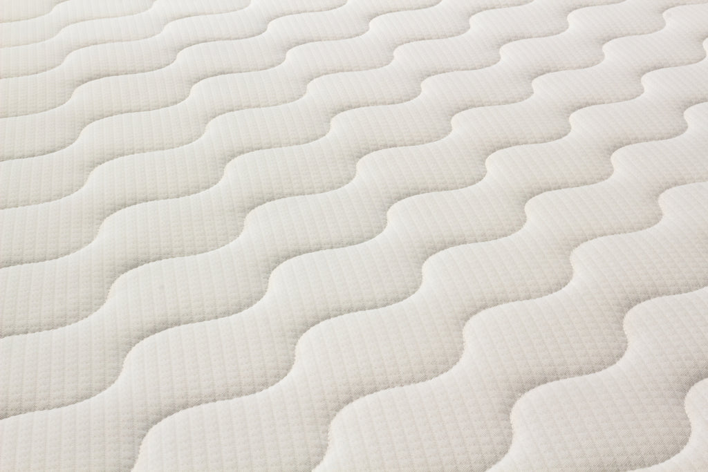 Close-up of a textured white mattress surface