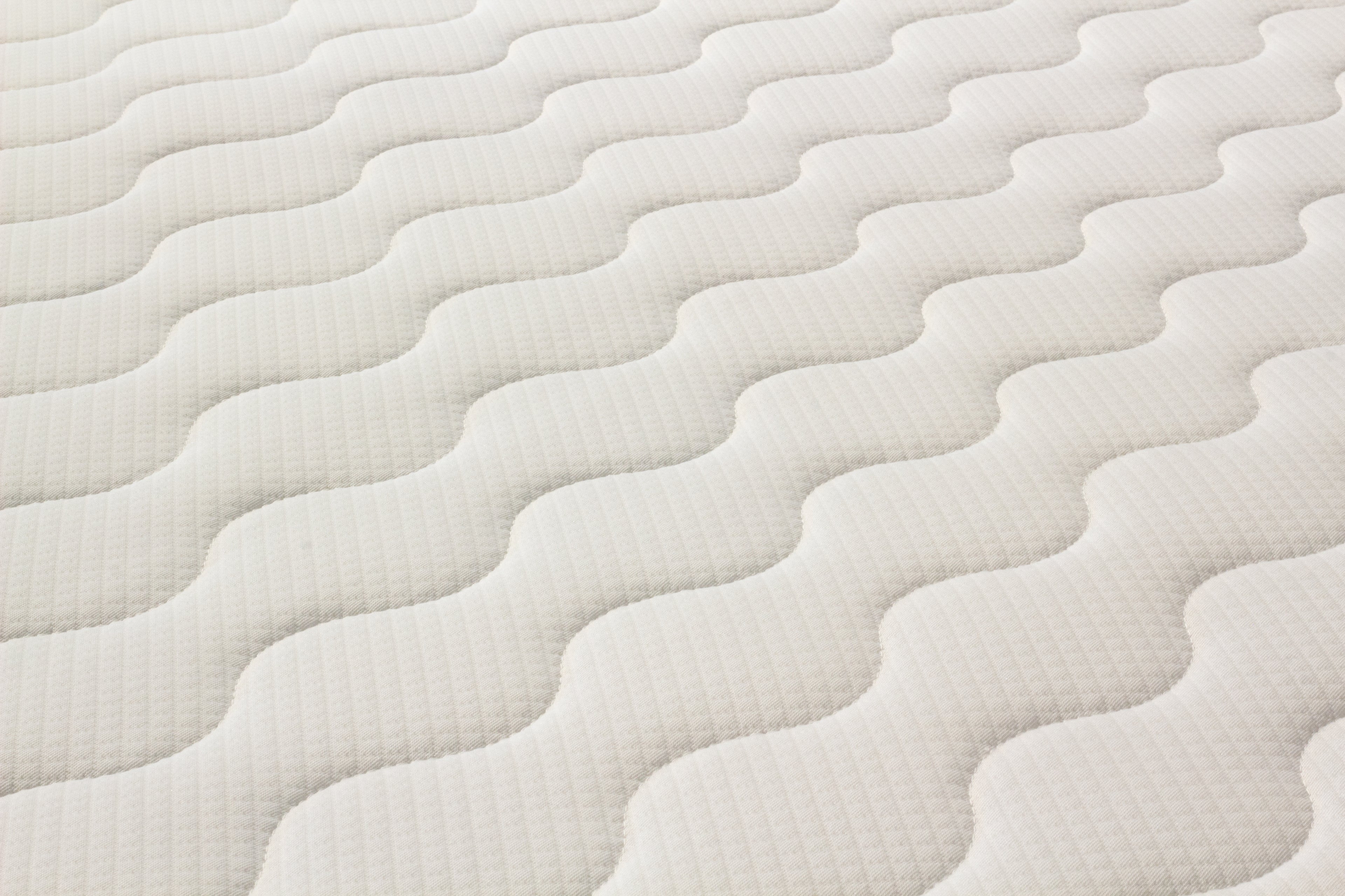 Close-up of a textured white mattress surface