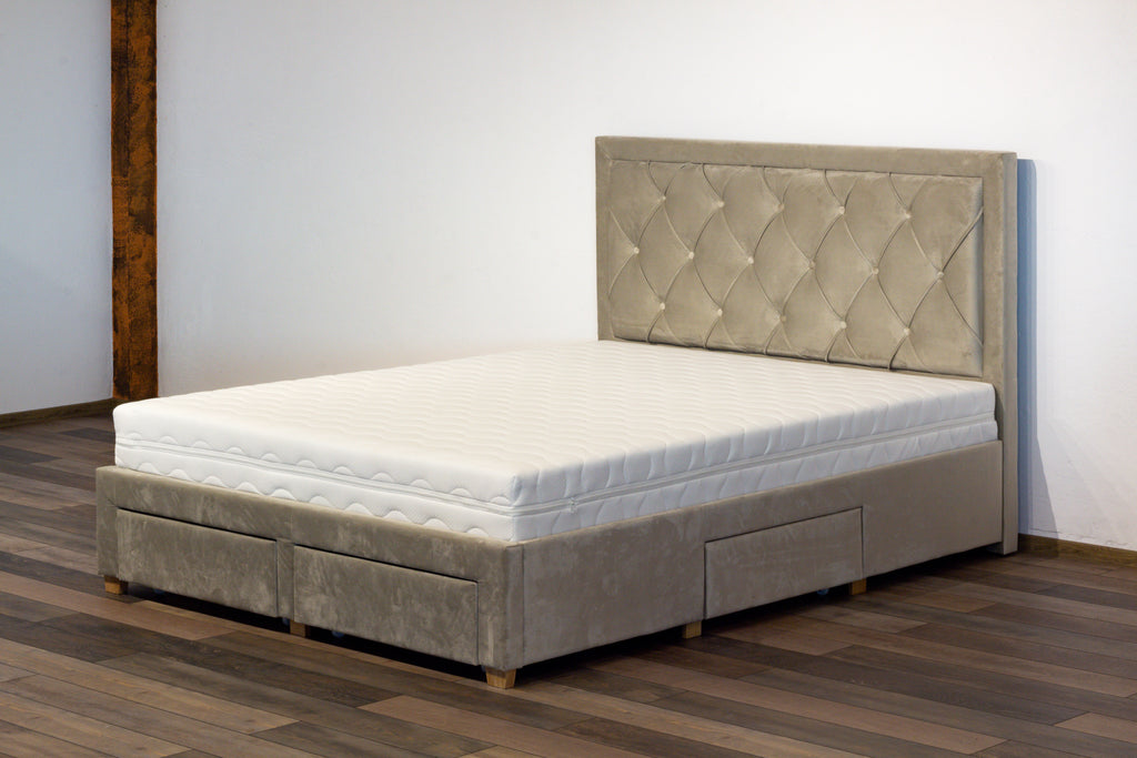 Gray upholstered bed with tufted headboard on a wooden floor.