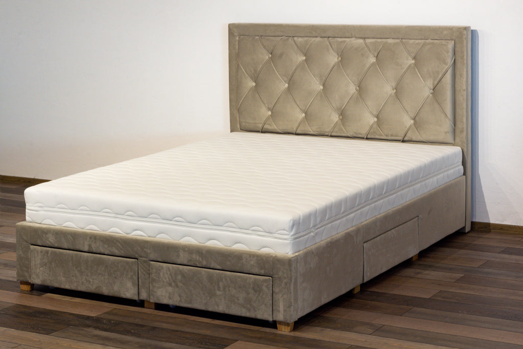 Gray upholstered bed with tufted headboard on a wooden floor.