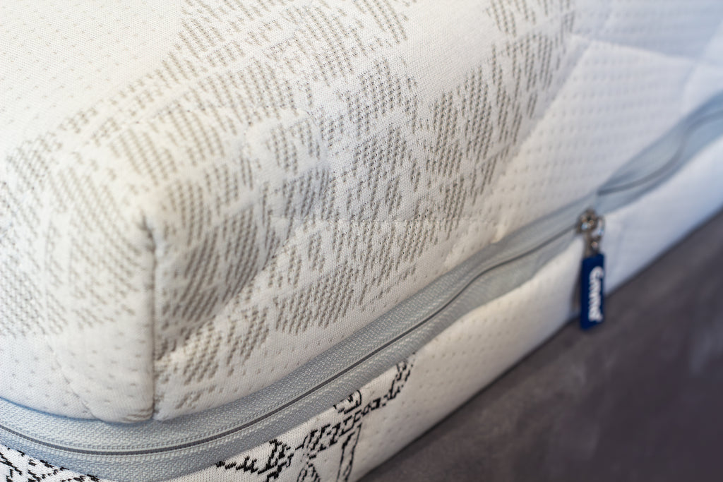 Close-up of a mattress with a brand label on a blurred background