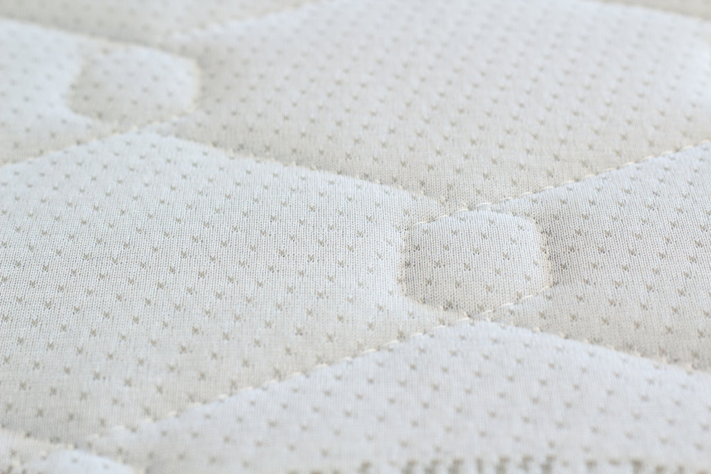 Close-up of a textured white mattress surface