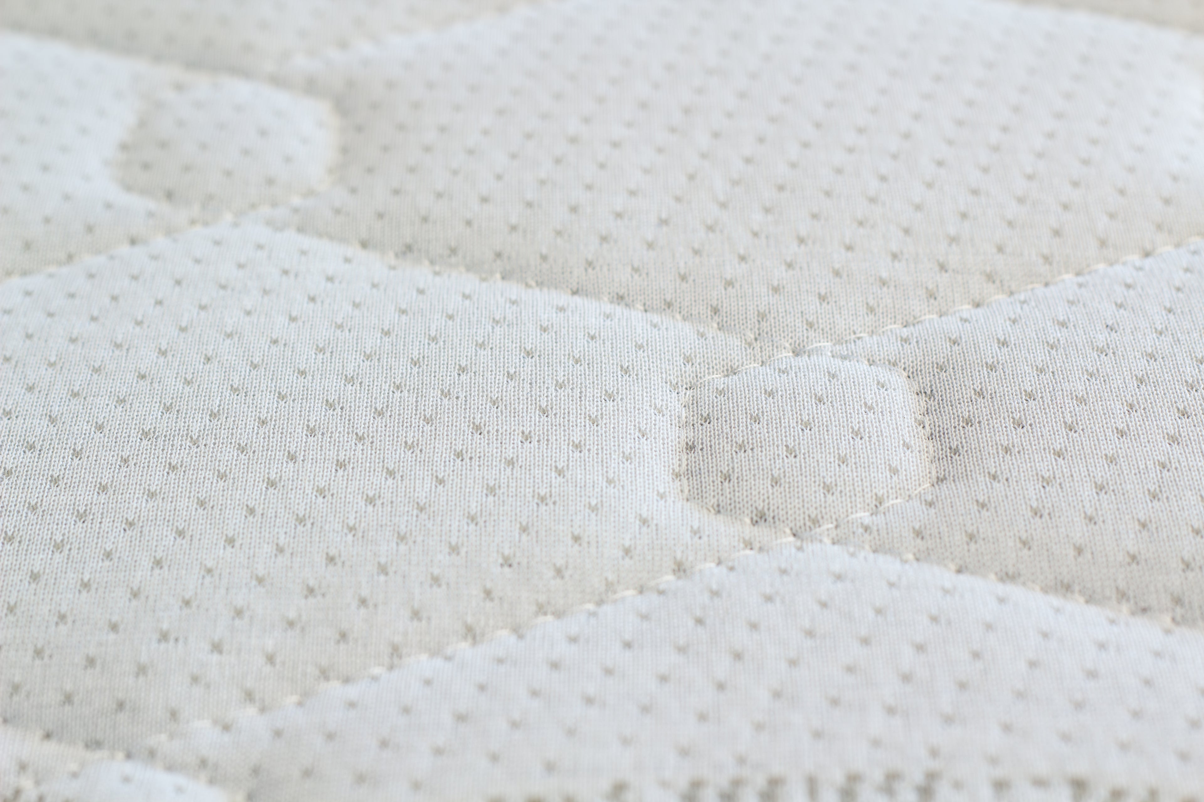 Close-up of a textured white mattress surface