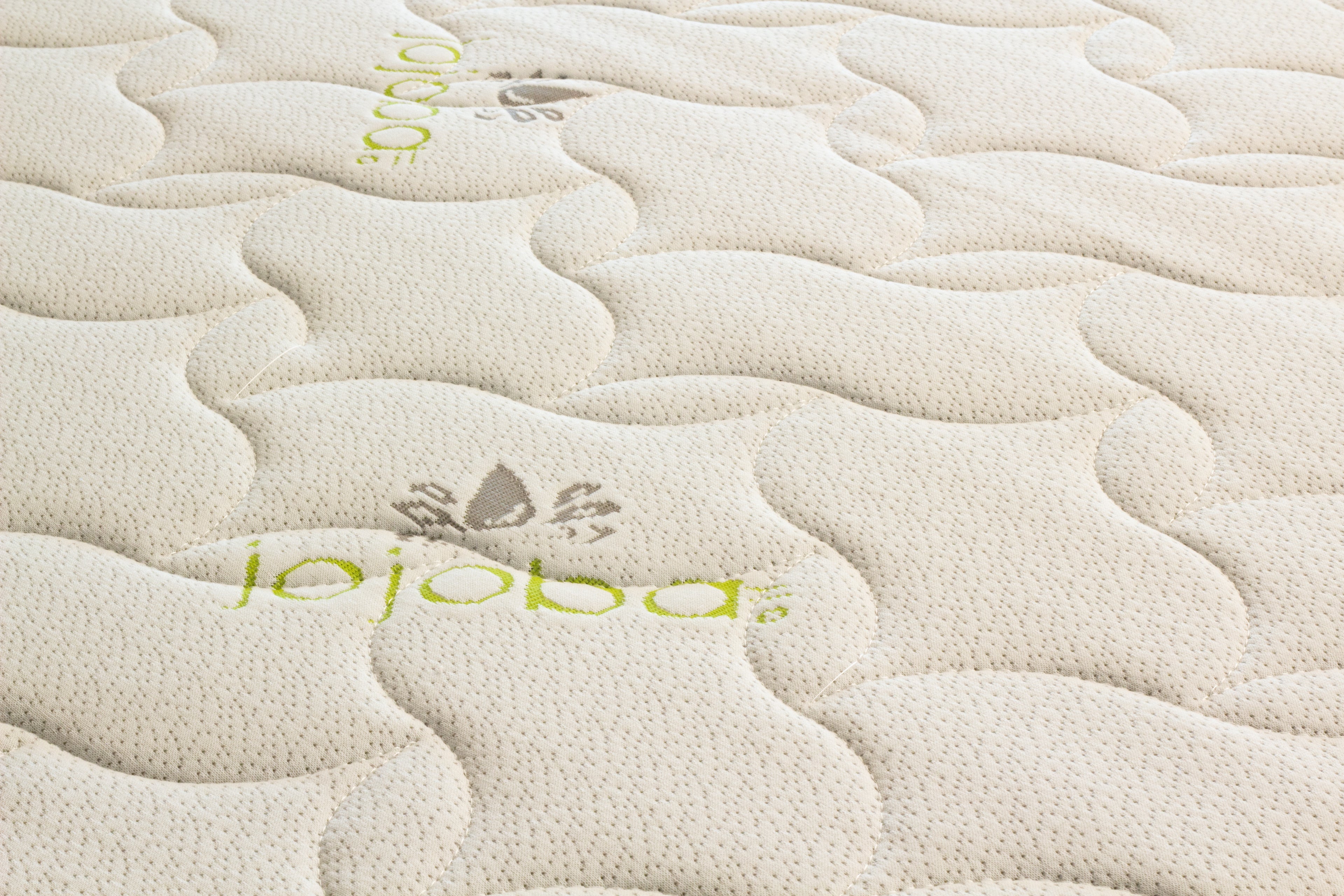 Close-up of a textured surface with 'jojoba' branding.