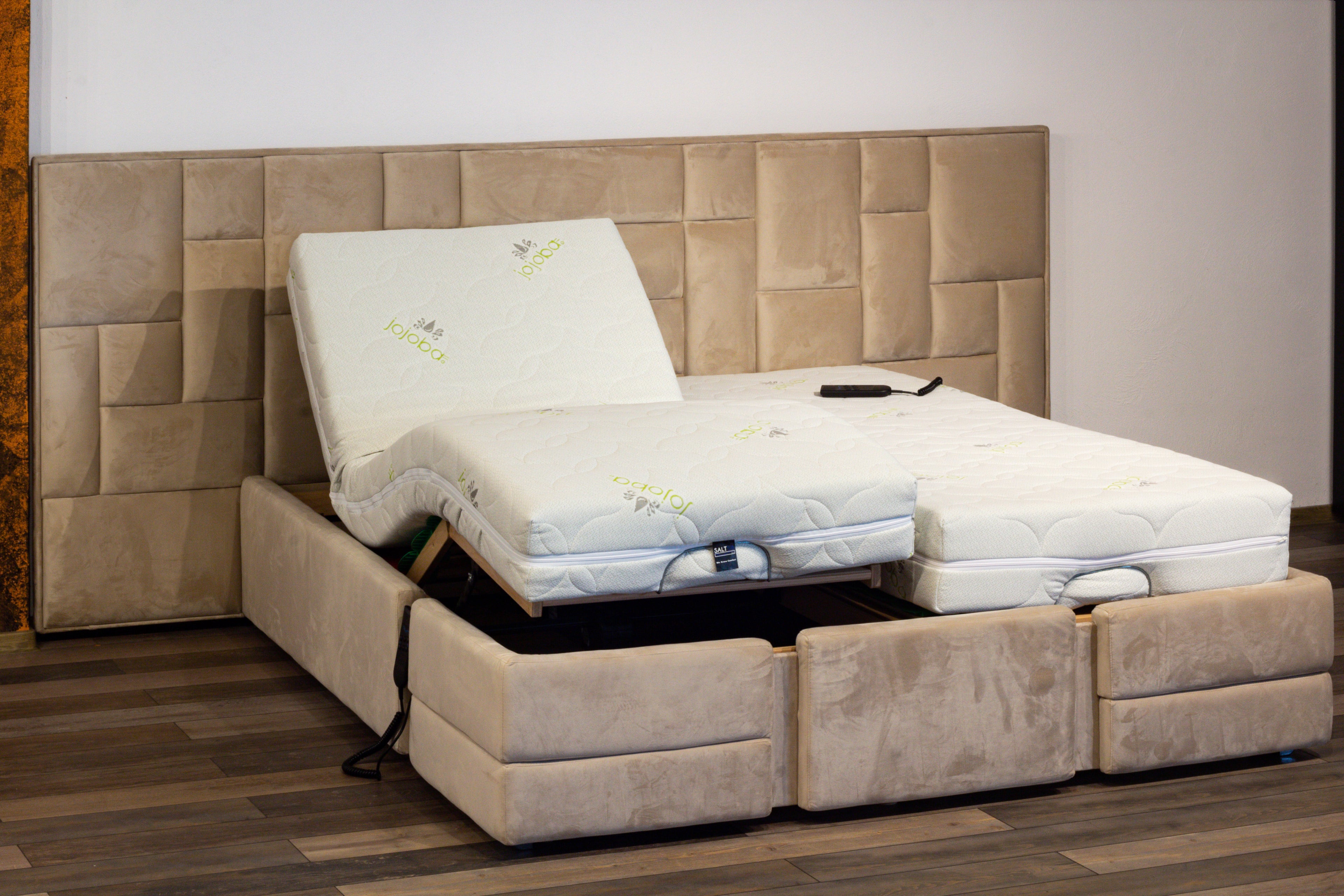 Beige adjustable bed with mattress in a room setting