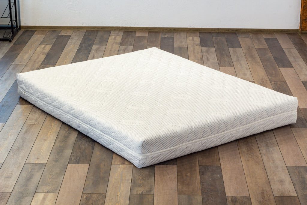 White mattress on a wooden floor