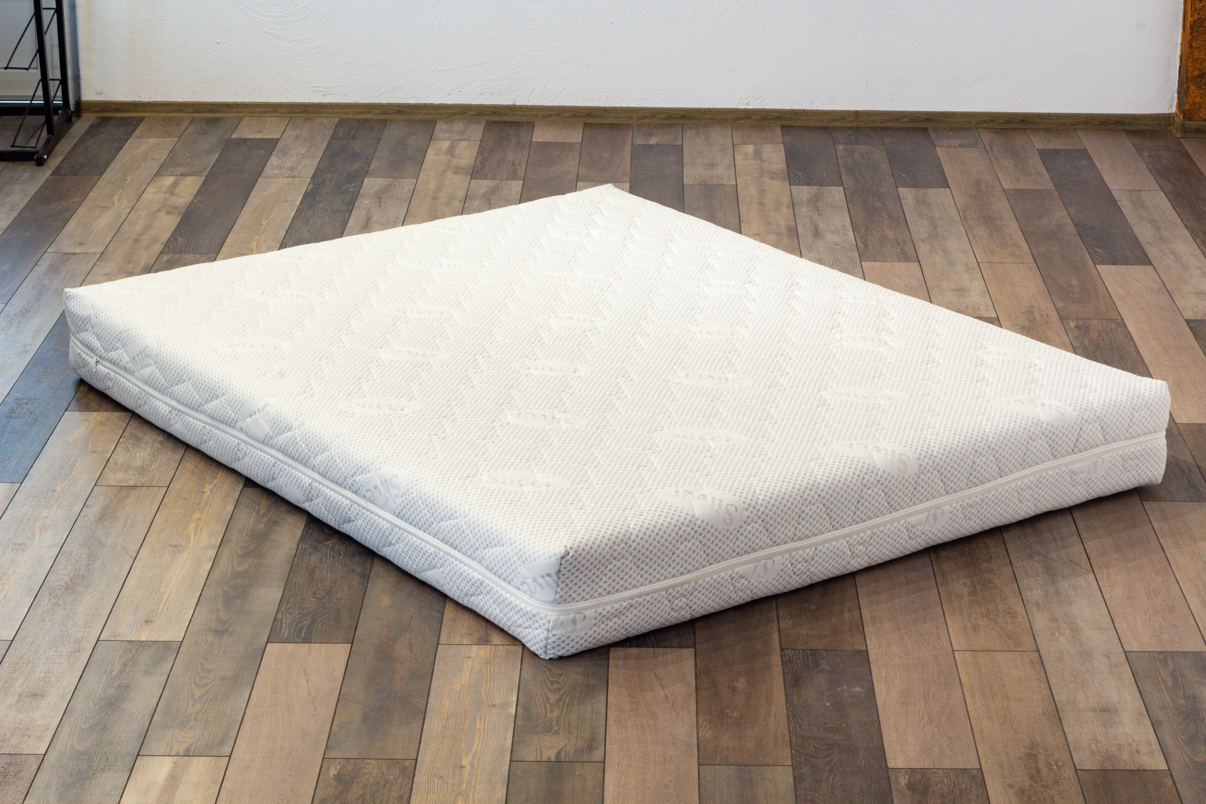 White mattress on a wooden floor