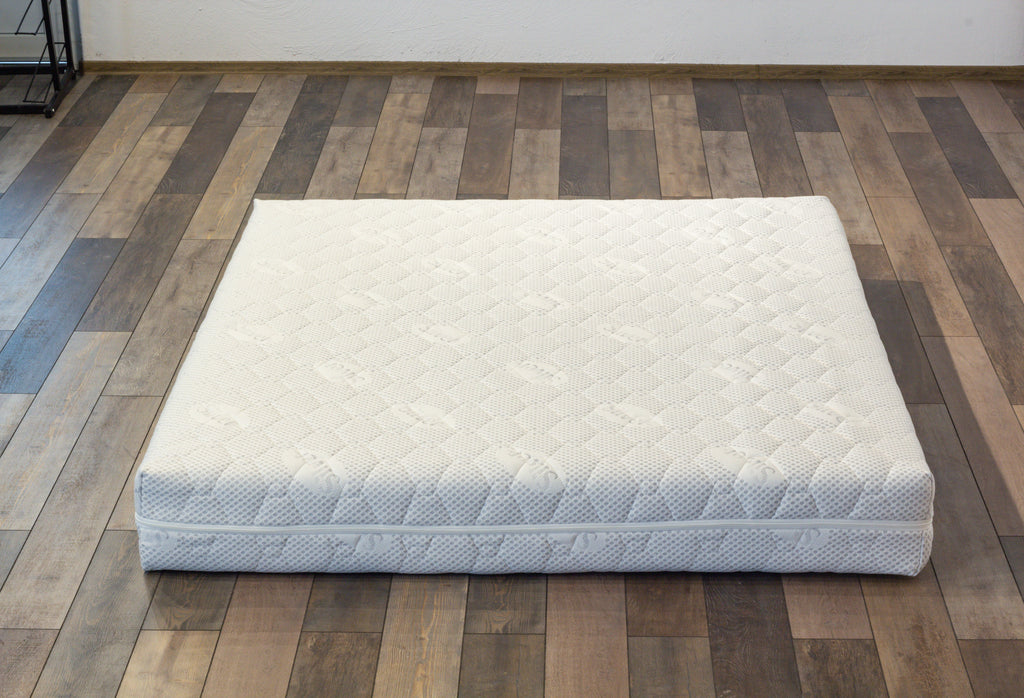 White mattress on a wooden floor