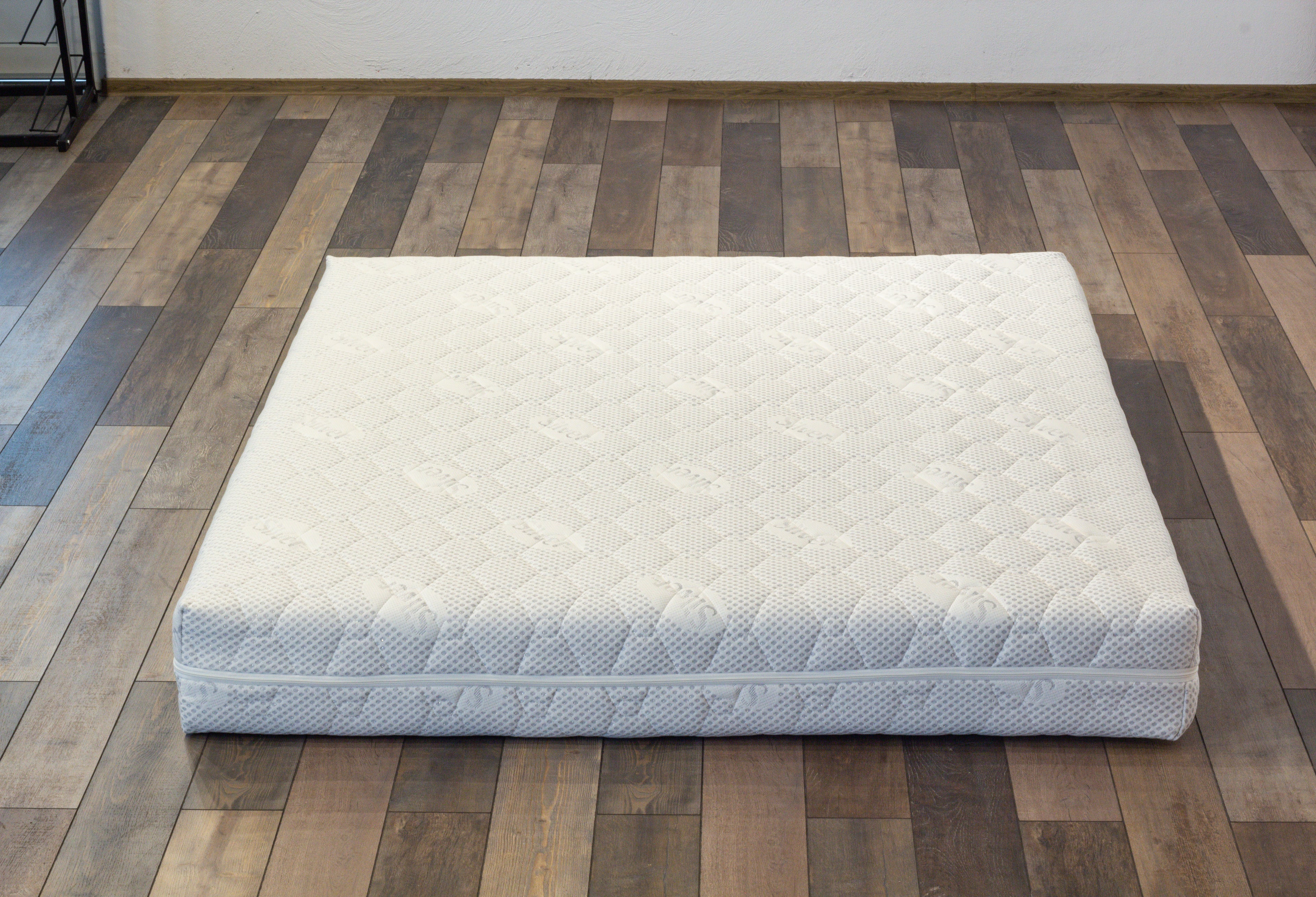 White mattress on a wooden floor