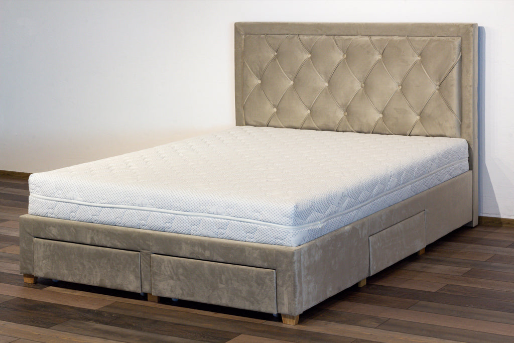 Gray upholstered bed with tufted headboard on a wooden floor.