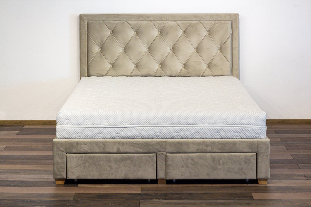 Beige tufted bed with mattress on a wooden floor