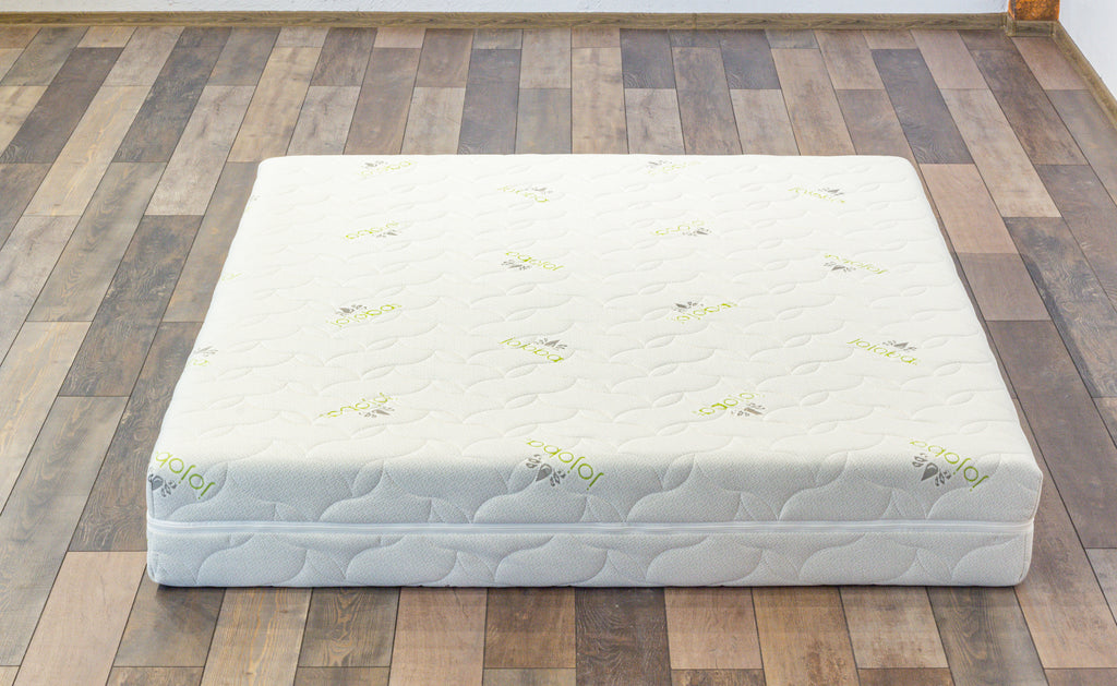 White mattress on a wooden floor