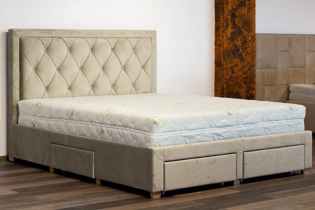 Beige upholstered bed with tufted headboard and storage drawers in a room setting.
