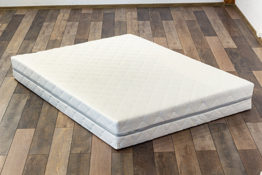 White mattress on a wooden floor